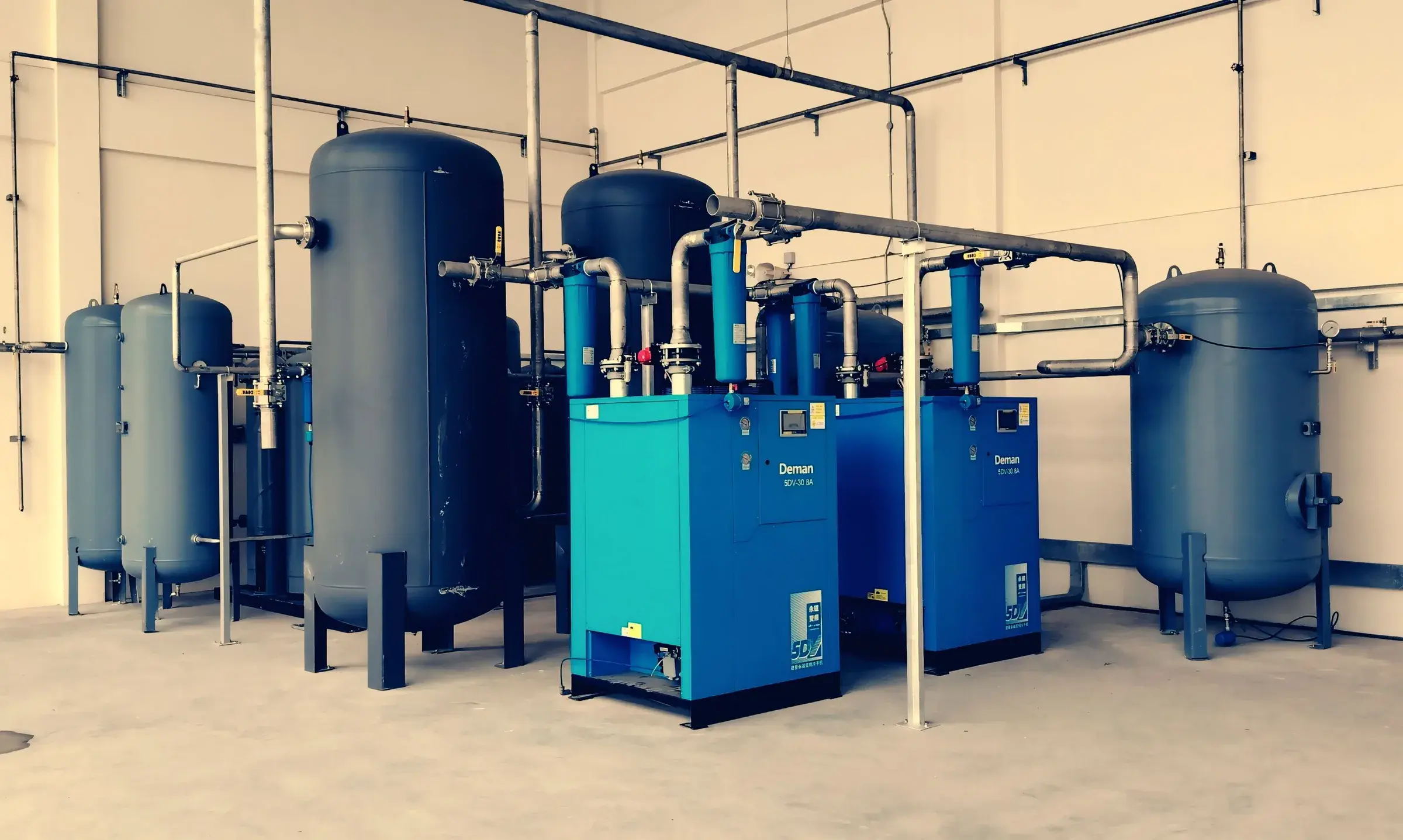 Compresseur industriel et cuves de stockage en intérieur d'usine